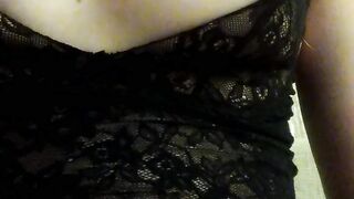 Home striptease in black lace lingerie and showing beautiful naked breasts. Close-up