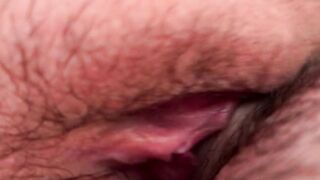 Cum flows from a meaty, swollen and fucked up pussy. Close-up.