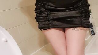 Girl in little black dress peeing while standing up and showing her ass and pussy