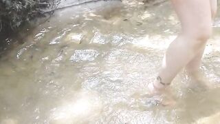 Cute long hair girl on her knees looking for shells to collect in popular spring creek part 2