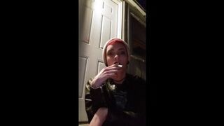 punk smokes a cigarette outside at night