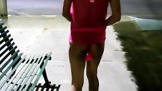 Sissy in chastity and slutty lingerie masturbating her ass with dildo in a public park at night.