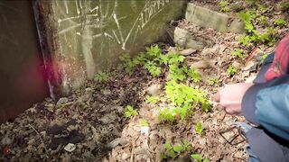 Bearded guy pissing in the forest. A man relieves himself in nature