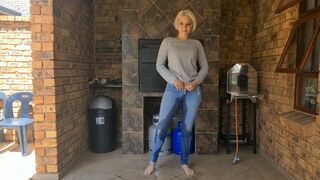 Desperate blonde needs to piss so she stood outside on the porch and pissed in her blue jeans